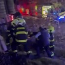 Záchranári pomáhajú zraneným po zrážke vlakov